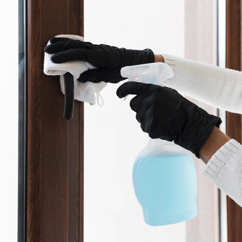 hands-with-gloves-disinfecting-window-handle